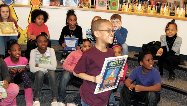 Third-grader Quince Clarke shows students at H.B. Wilson Elementary in Camden, N.J., a book he has read about the first 100 days at school, during a videoconferencing session at Creekside Elementary Wednesday. Twenty-one Creekside students participated in the event.
