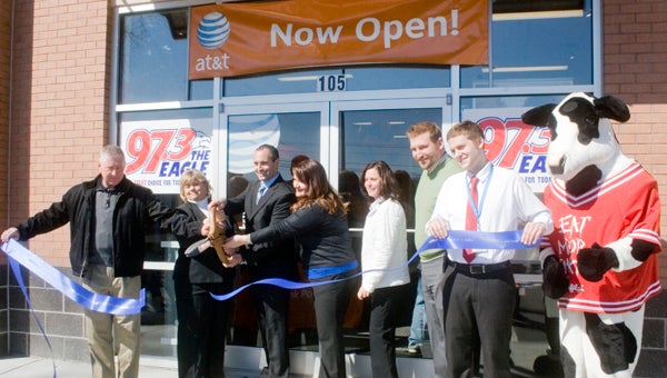 Suffolk City Council member Roger Fawcett, left, and Mayor Linda T. Johnson, help Brian S. Wainwright, president of The Wireless Experience, cut the ribbon Friday at his company’s first Suffolk location. The store at Main Street Marketplace officially opened in February.