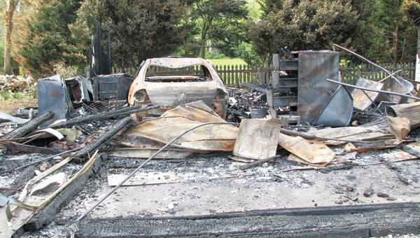 Carolyn Harris’ leveled garage and torched car are pictured Friday morning. Some neighbors suspect the work of a serial arsonist in this and three other fires in the neighborhood since October.