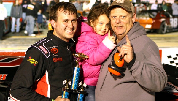 C.E. Falk stands in Victory Lane with crewman Randy Armstrong and Armstrong’s daughter after Falk’s 125-lap victory in the Late Model Stock Car class at NASCAR Whelen All-American Series program at Langley Speedway in Hampton on Saturday.
