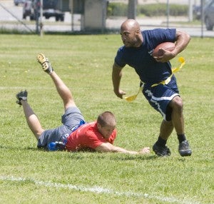 Antonio Diggs of the Suffolk Police Department evades the tackle attempt by Steven Speight of the Suffolk Department of Fire and Rescue during the two organizations' second annual flag football Relay For Life fund-raiser on Saturday at Peanut Park. The police department's team won in overtime, 17-14.