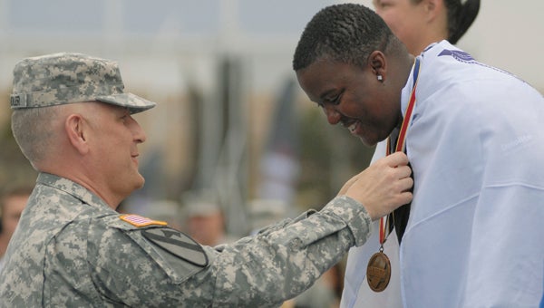 Sgt. Maj. of the Army Raymond F. Chandler III awards a track and field gold medal to Sgt. Monica Southall after she won gold medals in the standing discus and standing shot put, at the Warrior Games on Tuesday.