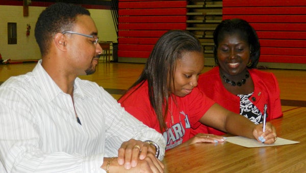 Nansemond River senior Sonnae Gibson's parents, Sonny and Tammy Gibson, look on as she signs to play basketball for Virginia Wesleyan College during a ceremony on Wednesday at Nansemond River High School.