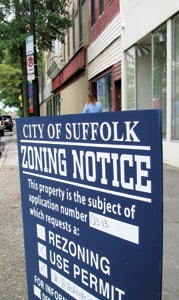 The Planning Commission delayed a decision on a conditional use permit for a proposed new loft apartment development on West Washington Street, seen here behind the sign announcing the public hearing.