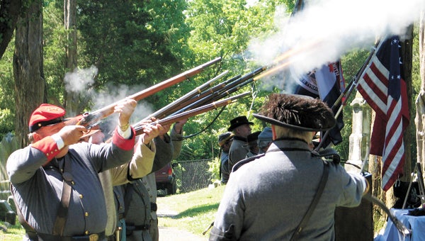 Confederate re-enactors fire a rifle salute at the Suffolk Chapter 173 United Daughters of the Confederacy Memorial Day ceremony on Saturday at Cedar Hill Cemetery.