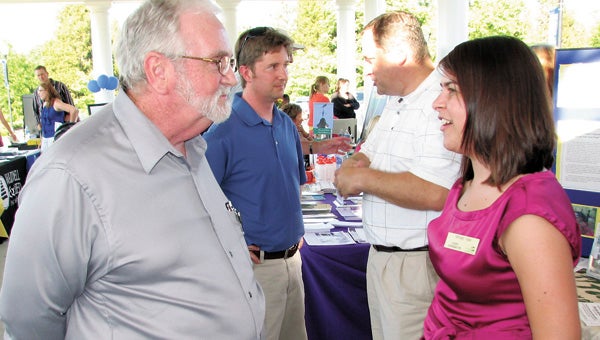 Jim Williams and Tiffany Vick of the Airfield 4-H Conference Center in Wakefield chat during the Mingle on Main Street event on Thursday evening.