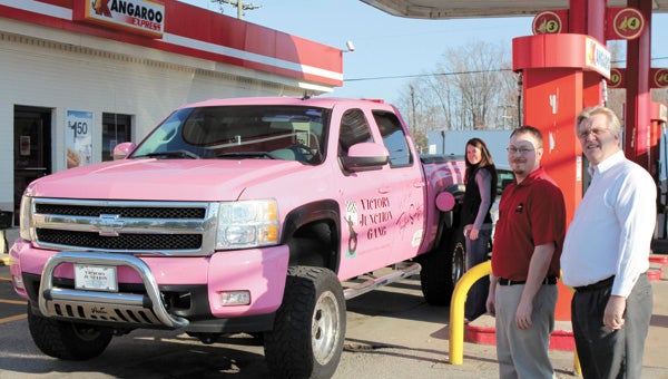 Nicole Connor gasses up the Victory Junction Pink Truck, donated by country star Taylor Swift, at Suffolk’s Wilroy Road Kangaroo Express during a visit in March. The visit thanked area Kangaroo employees like David Carr and David Stover, also pictured, for raising money for a camp for sick kids.