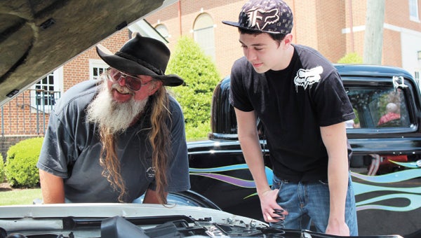Andy and Caleb Keaton traveled from Culpeper County to look under the hoods of some antique vehicles at the Shake, Rattle & Roll car show in downtown Suffolk on Saturday.