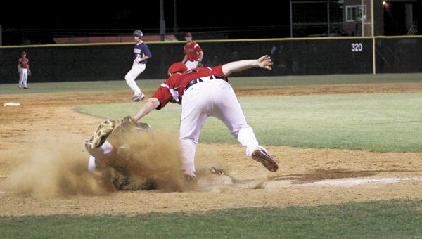 Nansemond River sophomore Robert Fitzwater tags out the Western Branch High School runner as he slides into third base on Friday night. The Warriors made a game of it, but ultimately were out-scored 8-7 to end their season in the quarterfinals of the district tournament at Nansemond River High School. (Wil Davis photo)