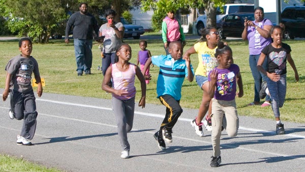 Ten-year old Quanisha Bailey leads a pack of runners during a heat of the 200-meter dash as part of the 2013 Hershey Track and Field Event on Tuesday at Planters Park. Top performers from Tuesday will have the opportunity to advance to a national competition in Hershey, Pa.