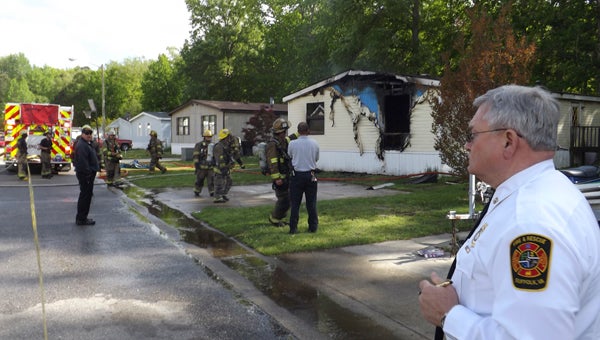 Deputy Fire Chief Ed Taylor supervises as firefighters work the scene of a fire in a mobile home park off Nansemond Parkway. Six people were displaced from the home. 