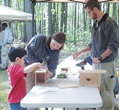 AmeriCorps volunteers Brienna Rainey and Jared Schopp help a boy at the Great Dismal Swamp Birding Festival on April 27. They are from Phoenix 2, a team that actually comes here to work on prescribed burns, but has so far been rained out.