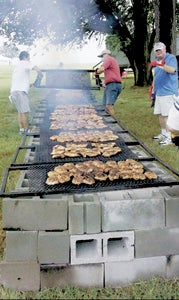 Volunteers cook up some tasty morsels at a previous annual fundraiser for the Churchland and Portsmouth Rotary clubs. The popular event will be held at the site of the old Tidewater Community College in North Suffolk on June 19.