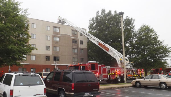 A ladder truck extends to the fifth floor of Chorey Park Apartments on Friday evening while fighting a fire.