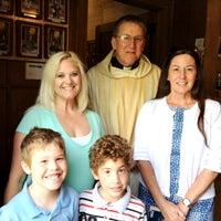 Fr. Ken Wood, pastor of St. Mary Church in Suffolk, greets parishioners, from left, Amanda Moegenberg and her sons Travis and Joseph, and Cheryl O’Connor.