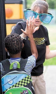 Karen Jones, a counselor at Kilby Shores Elementary School gives a high-five to first-grader Jeremy Briscoe.
