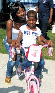 Sharell Murray and her daughter, Shaniyah Winfield, 5, get used to Shaniyah’s new bicycle, donated by Massimo Zanetti.