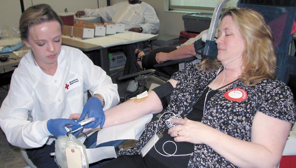 American Red Cross technician Kelsey Ferguson takes a blood donation from Cynthia Bunch at the Suffolk Health and Human Services Building on Monday afternoon. The Mayor’s Cup blood drive continues today at the North Suffolk Library.
