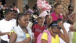 Students at Booker T. Washington Elementary School leave for the summer as teachers and other staff cheer them on.