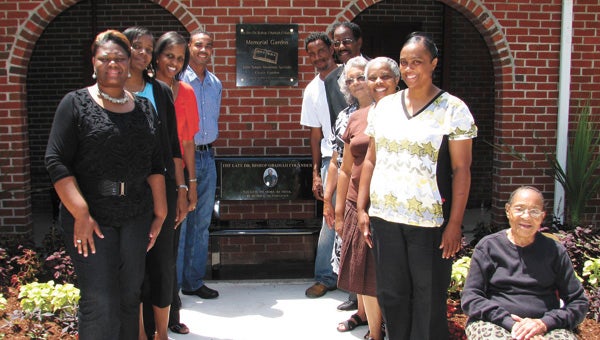 Family members of the late Obadiah Colander show off the memorial garden. From left are granddaughters Jeanette Ruffin, Ona Nickelson and Amy Lansford, Faith Temple Pastor Troy Ruffin, grandson Alfred Colander Jr., son Alfred Colander Sr., daughter-in-law Jeanette Colander, daughter Rita Turner, granddaughter Vera Colander and cousin Dorothy Bivins. Family not pictured are wife Bernadine Colander, children Ralph Colander Sr., Rudolph Colander, Bishop John Colander, Barbara Green, the late Alethia Colander-Stokes and the late Harlena Colander, as well as stepsons Bishop Joseph Colander and Dwayne Miller.