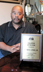 Suffolk’s Lemuel Jones, southeastern director of the Virginia PTA, would like to see more dads involved in parent-teacher associations. He is pictured at home with his Suffolk PTA Council Volunteer of the Year Award.