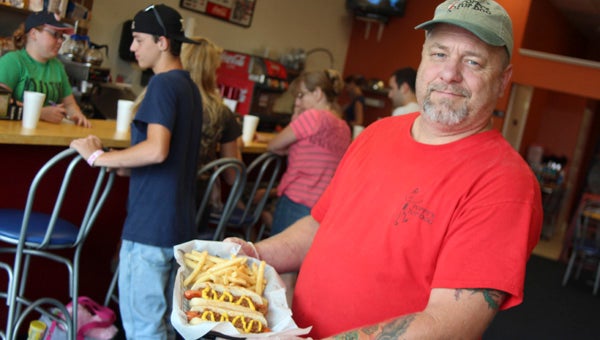John Sumner, owner of Poppy’s Top Dog, displays some dogs and fries at the new North Suffolk eatery. 