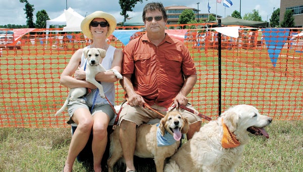 Mark and Sarah Lascara of Chesapeake adopted Snowflake — sitting on Sarah Lascara’s lap — at last year’s Passion for Paws Picnic. The dog joined Ginger, center, and Molly, right, in this dog-loving home.