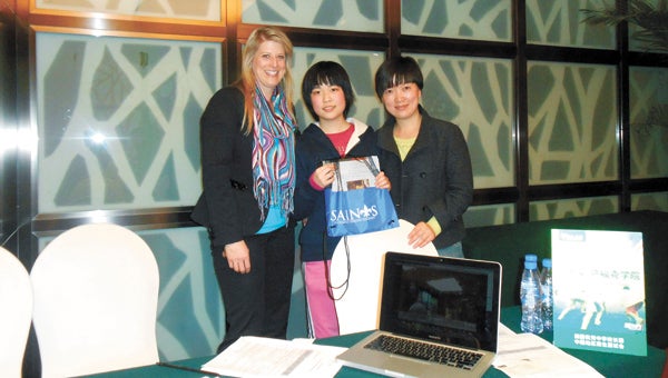 Debbie Russell, head of Nansemond-Suffolk Academy, exchange student Faye and her aunt stand at New Oriental American Private High Schools Fair. Russell recently took a trip to China to learn about its culture and meet with exchange students.