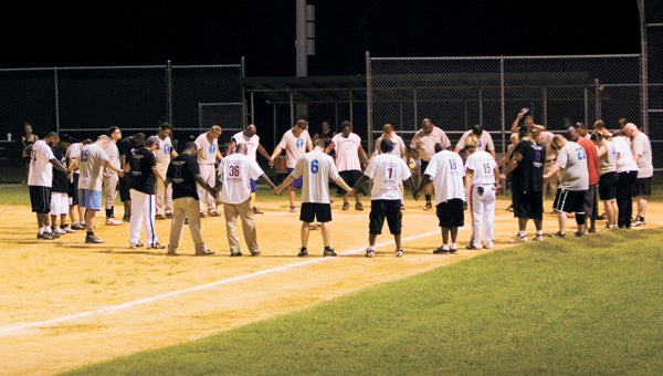 Fellowship between churches is a major benefit experienced through Suffolk's co-ed church softball league. St. John's Christian Church and Southside Baptist Church pray together before Friday night's spring championship game at John F. Kennedy Middle School.
