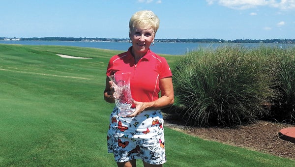 Suffolk native and current Churchland-area resident Vickie Lombard holds the cup signifying her win in the 2013 Ladies Club Championship at Cedar Point Country Club last Sunday. She has won the event multiple times, a result borne out of her love for the game and the club, of which she has been a member since the 1970s. (Photo submitted by William Evans)