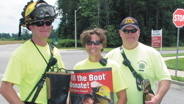 Firefighter Chris Asbell, Lt. Laurina Lopez and Firefighter David Dickens collect donations for the “Fill the Boot” campaign on Wednesday near the 7-Eleven on Centerbrooke Lane. The international event supports the Muscular Dystrophy Association.