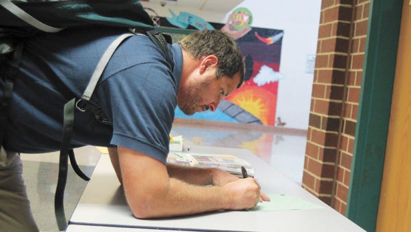 Clay Scott, one of scores of new teachers with Suffolk Public Schools this school year, fills out a form after an orientation session at King’s Fork Middle School Tuesday. “I’m a veteran (teacher) new to Suffolk,” Scott said.