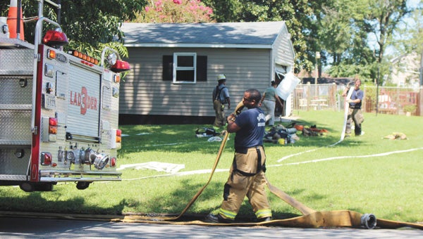 Firefighters clean up after they finish at the Walnut Street fire on Monday.