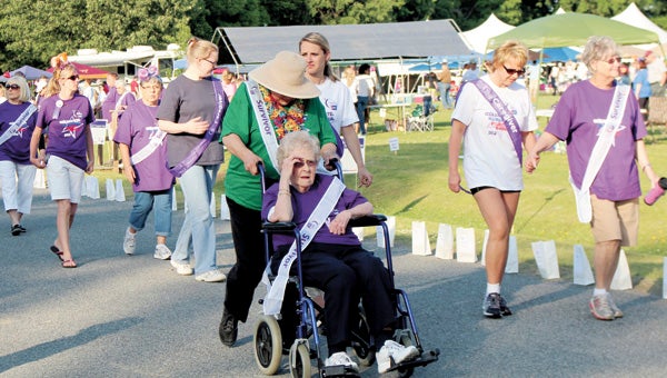 Record: Survivors and caregivers take the first lap around the track at Bennett’s Creek Park during the 2013 Relay For Life. The event surpassed a fundraising record for the Suffolk Relay, organizers said.