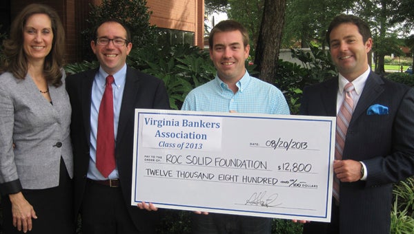 Diane Smith of Fulton Bank, Phil Harvilla of Sandy Spring Bank, Eric Newman of Roc Solid Foundation and Andrew Stone of Monarch Bank participate in a check presentation for the Roc Solid Foundation from the Virginia Bankers School of Bank Management on Aug. 20.