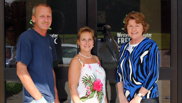 John and Ginger Kennedy and executive director Miriam Beiler, right, stand in front of Western Tidewater Free Clinic, which recently netted $50,000 from the sale of a property the Kennedy’s donated to the clinic.