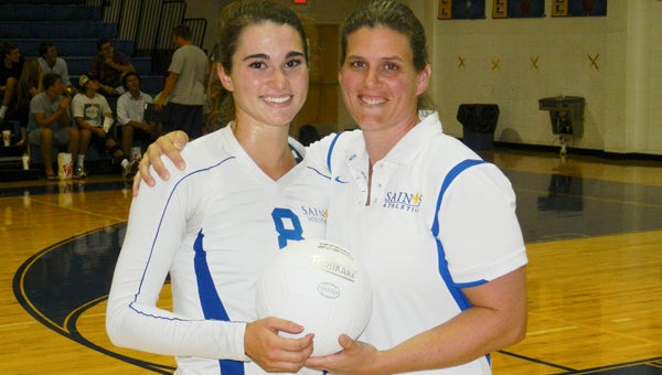 Nansemond-Suffolk Academy senior outside hitter Kaylor Nash holds the game ball with head coach Robyn Ross on Monday after Nash hit her 1,000th career kill with the Lady Saints. Nash credits Ross with teaching her everything that has helped her reach this milestone. It is only the second time in school history it has happened.