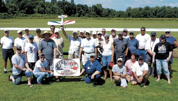 Surrounded by fellow club members, Bob Howell, president of Hampton Roads Radio Control Club, holds a model plane that has flown in all lower 48 states. It’s flying across America, and HRCC members got the chance to take the controls last Sunday.