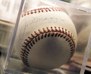 A baseball autographed by Joe DiMaggio.