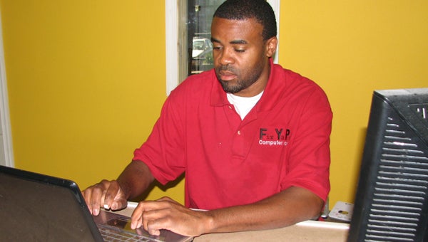 Jay Lewis works on a computer at Fix Ya PC at Freedom Plaza. He expanded the business from its former Gittings Street location.