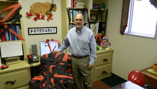 Dr. Doug Gregory, team physician for Western Branch High School, stands in his Lakeview Medical Center office, which features a Nansemond River High School-themed redecoration. It is the latest move by his granddaughter, Shelby, a senior at NR, in what has been a four-year rivalry between the two.