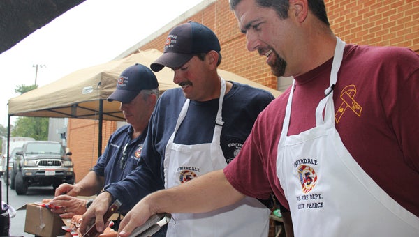 The Rev. Randy Wright, Captain David Blythe and Allen Pearce of the Hunterdale Volunteer Fire Department grill hot dogs for the hungry visitors during the Paul D. Camp Community College Alumni Reunion and Open House recently at the Regional Workforce Development Center in Franklin.