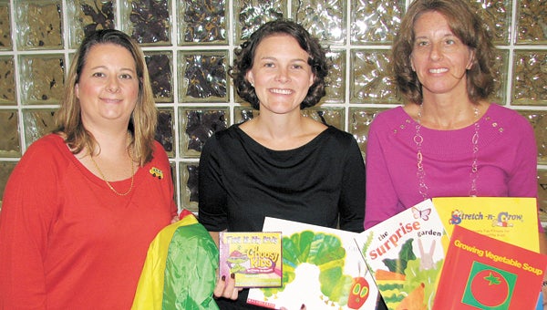 From left, Betty Jo Harville, assistant director of Growing Up at Obici, Marissa Spady, nutrition education specialist with The Planning Council, and Robin Abbey, director of Growing Up at Obici, show off some of the educational tools and incentives they have used in a program to improve the health of children in private daycares in the area.