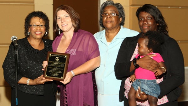 Sheena Carach, second from left, receives an award for her lifesaving efforts. Pictured are Delegate Roslyn Tyler, Carach and members of Demetrius Taylor’s family: Shirley Ellis, Danielle Taylor and a baby cousin.