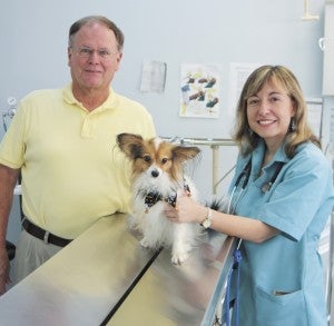 Veterinarians Woody Kessler — its owner — and Jennifer Cochran, pictured with Cochran’s Papillion “Chase,” are planning a weeklong celebration in early November to mark Nansemond Veterinary Clinic’s 75th anniversary. 