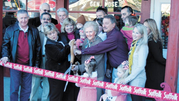 In Chuckatuck Saturday, 97-year-old Eloise Bailey shares the scissors to officially open the renovated Gwaltney store. Bailey, great-aunt of the individual largely responsible for the restoration, Kent Gwaltney, pictured to her right, flew in from Nashville for the event. Her brother, George Lafayette Gwaltney, took over the business in the 1920s. “I think my brother is looking down on us,” she said. Also crowding in are city officials, councilmen Roger Fawcett and Mike Duman, Sheriff Raleigh H. Isaacs, Treasurer Ron Williams, and Mayor Linda T. Johnson; and Gwaltney family members, Carolyn Gwaltney, 3-year-old Andy Steele, Lindsay Steele, 1-year-old Ella Steele, Stephen Steele, Robert Warren, 3-year-old Adair Warren, April Warren, and Leslie Hamrick with Emma, 5, and Hannah, 4, Hamrick.