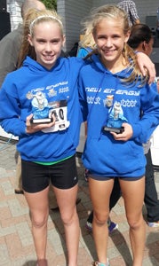 Suffolk runners Betsy Pollard and Cierra Sheppard celebrate after being victorious in separate races on Saturday in Virginia Beach. Sheppard took first in the girls’ 14-and-under age group of the Neptune 5K with a personal best time of 23:53, while Pollard won the girls’ 1-mile race.