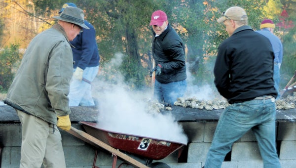 North Suffolk Rotary Club will hold its annual oyster roast Wednesday in Chuckatuck. Volunteer Brian Martin is pictured at last year’s event, waiting for his wheelbarrow to be loaded.
