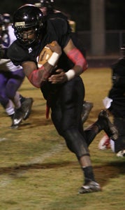 Nansemond River High School junior quarterback Jermaal Wells runs for more yardage on Deep Creek High School's defense Friday night. He ran for two scores, threw for one and caught an interception in the 34-20 home win that clinched a playoff berth for the Warriors.