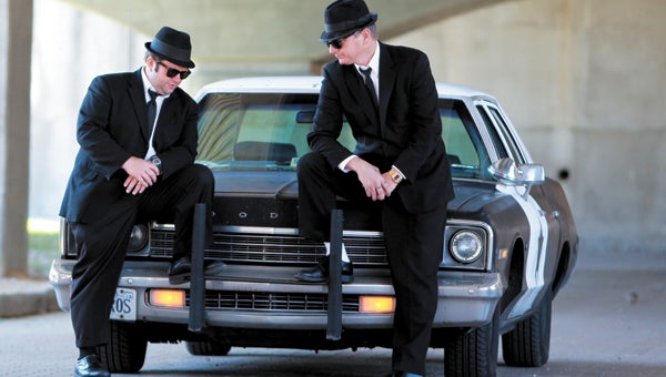 Kevin “Jake” Sweeney and John “Elwood” Vukovich, members of a Blues Brothers tribute band that will be perform in Driver Sunday, pose with their “Bluesmobile.”